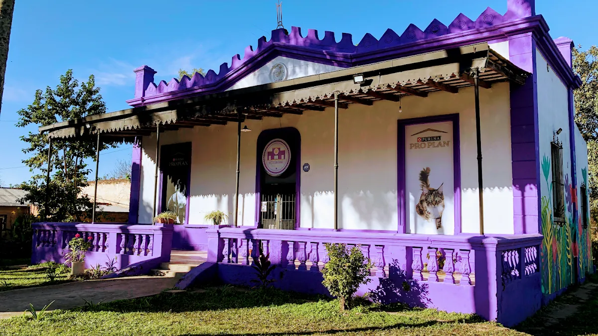 Frente violeta y blanco de la veterinaria, con galería y baranda